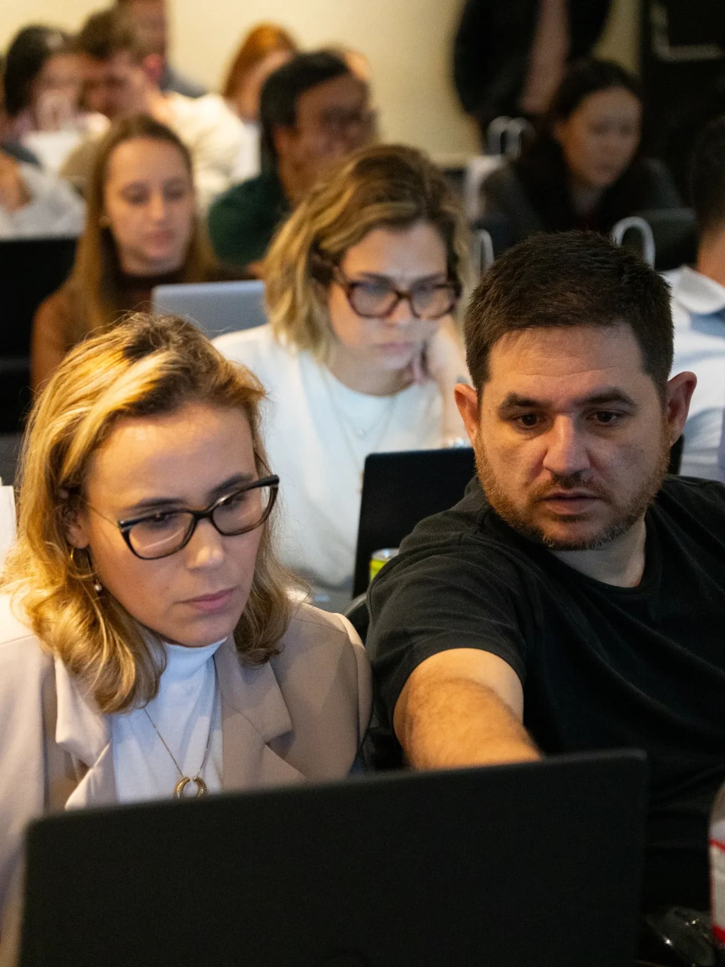 Participantes trabalhando juntos com um notebook na Operação IA.